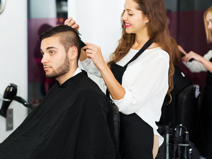Image of a woman giving a man a hair cut