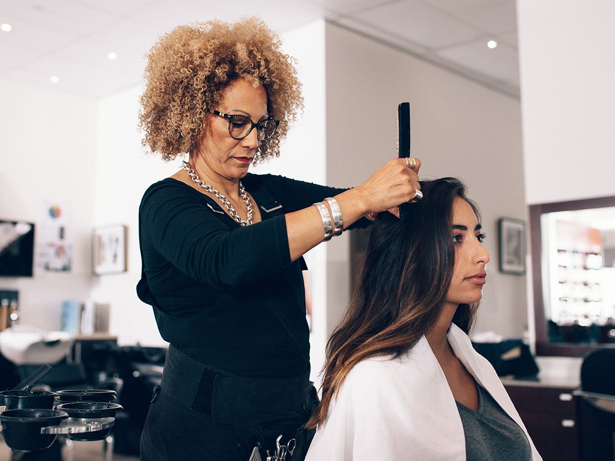 Woman hair stylist working on a client