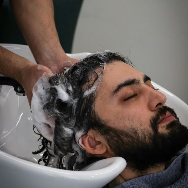 barber washing a man's hair