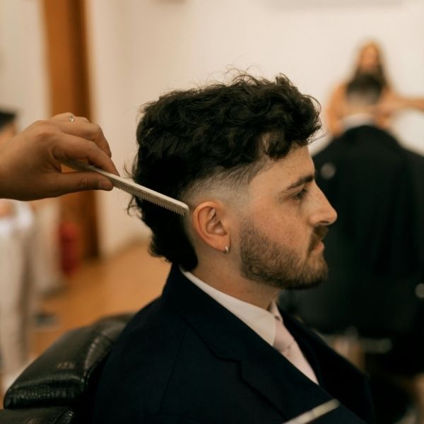 barber combing through a man's hair