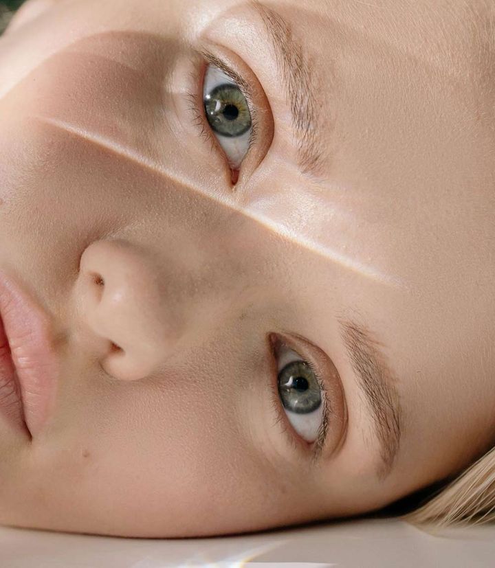 Young Female Laying Down And Looking Into Camera Thinking About Retinoids versus Retinols: What's the Difference and Which is Better?