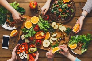 People eating at a table full of healthy food - Optimizing Nutrition Before and After Surgery