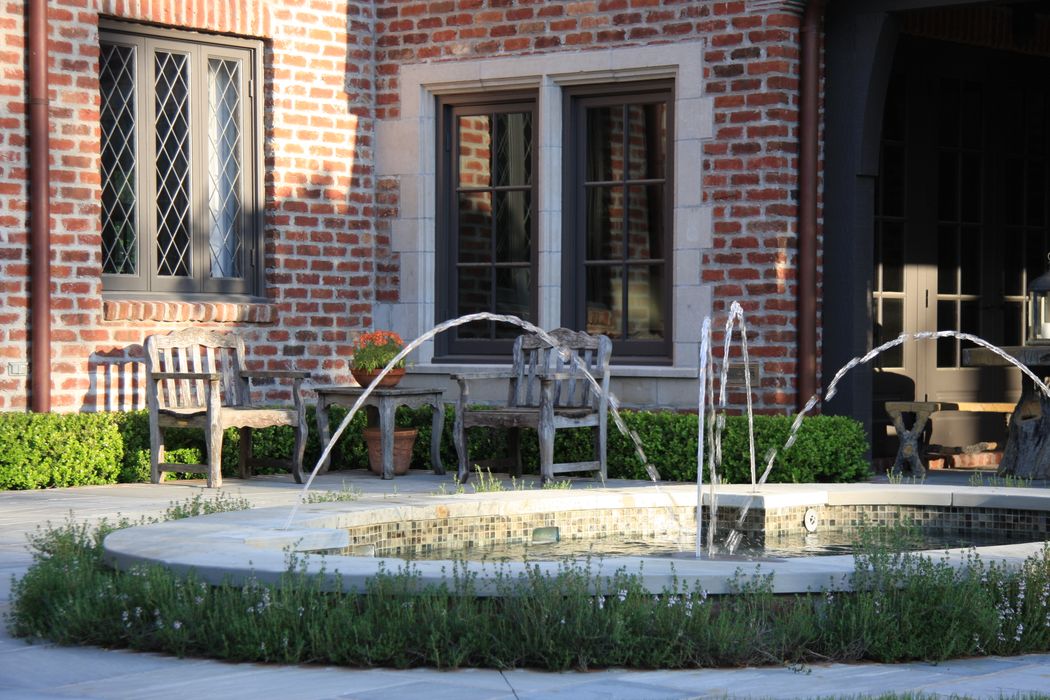 Elevated oval spa functioning as fountain feature on upper terrace of Tanglewood home.