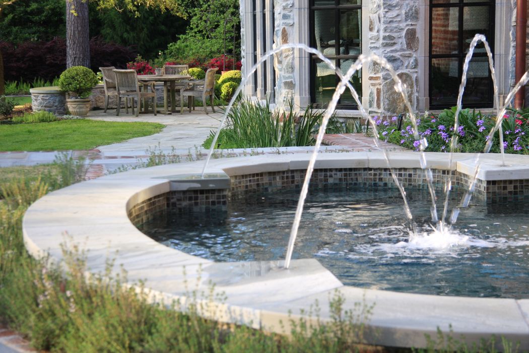 The oval spa’s flowing water enhances the vertical connection between the home’s terraces, reflecting the property’s layered architecture.