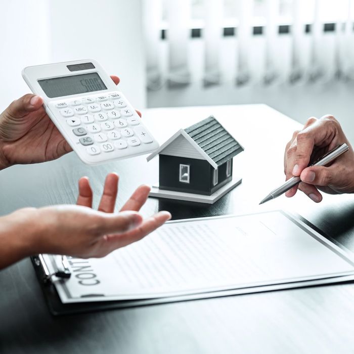 Person showing a calculator to another person while discussing loans. 