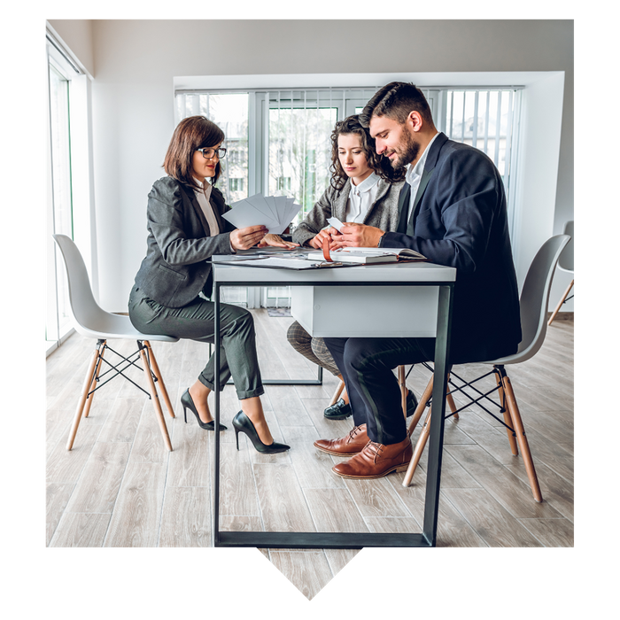 A realtor and clients sitting at a desk