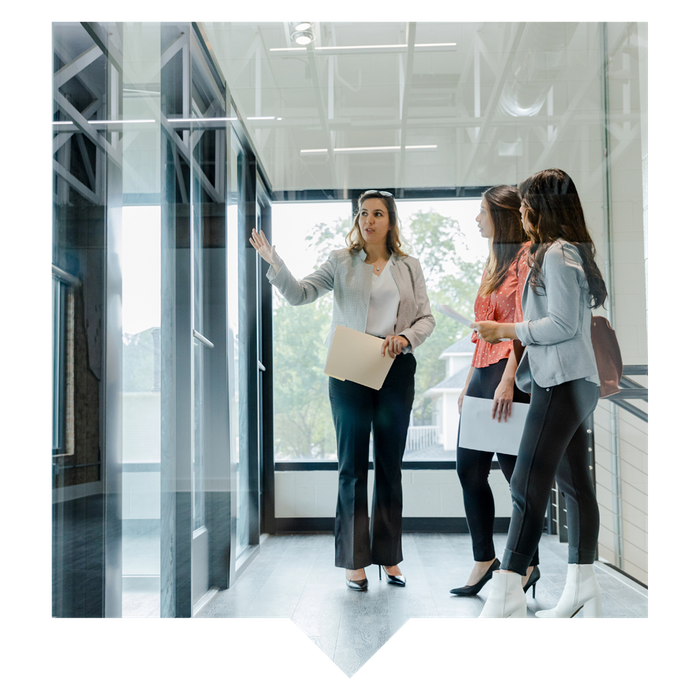 Realtor showing two business woman an office space