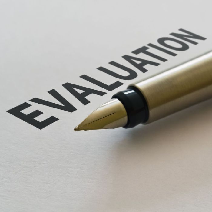 Piece of paper that says "Evaluation" with a pen sitting on it. 