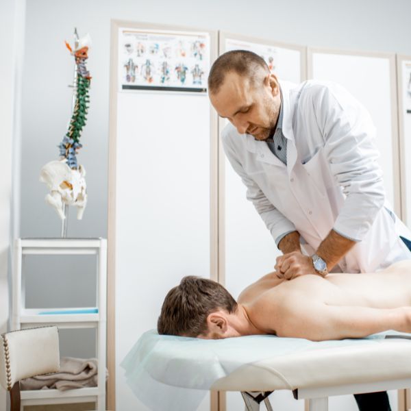 Chiropractor giving a male patient an adjustment.
