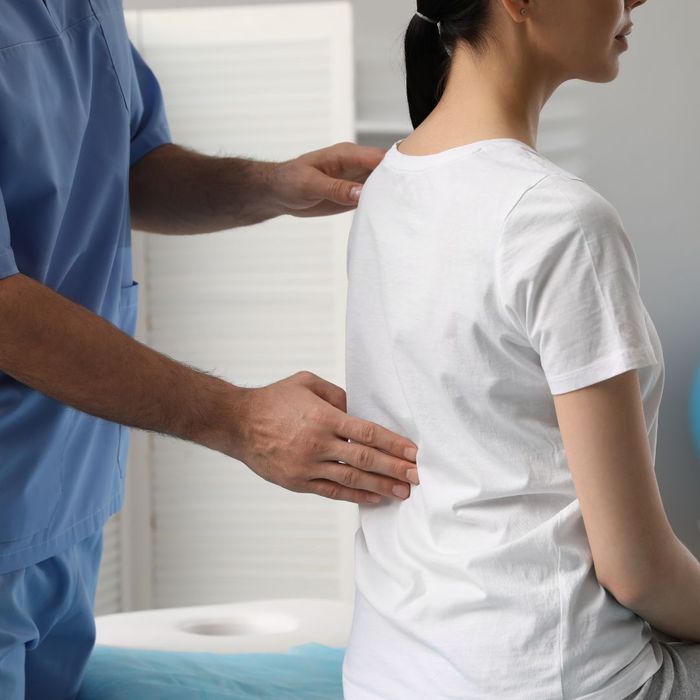 Chiropractor evaluating a woman's back. 