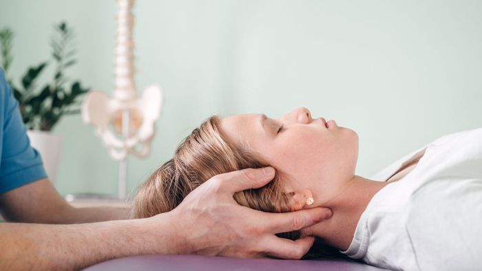 Woman getting her neck adjusted by a chiropractor. 