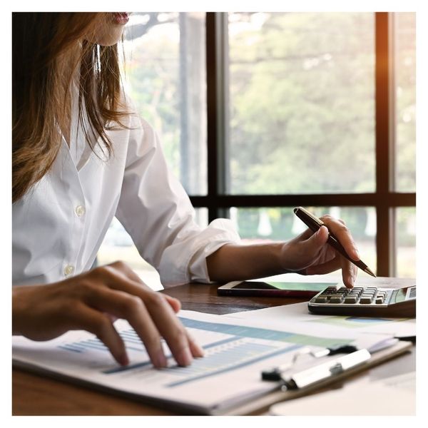 woman looking at reports and calculating numbers