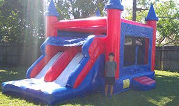 child standing next to bounce house