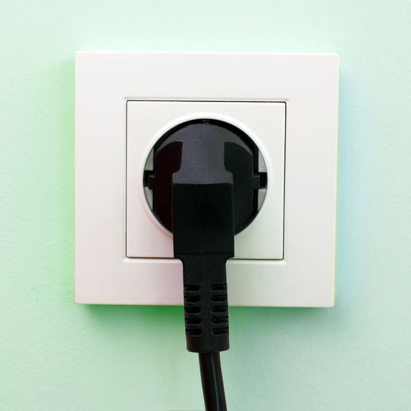 An electrical outlet with a black plug in it