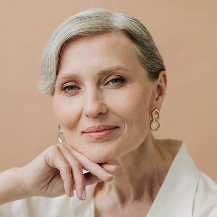 Portrait of an elegant older woman with glowing skin, showcasing successful skin rejuvenation results.