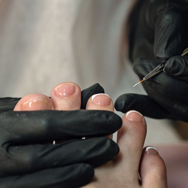 professional painting a client's toe nails