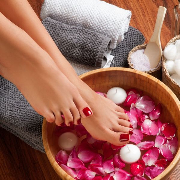 woman with feet in flower bath during pedicure woman with feet in flower bath during pedicure