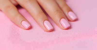 woman's hand with freshly painted pink nails
