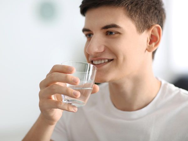 Young man drinking a glass of water
