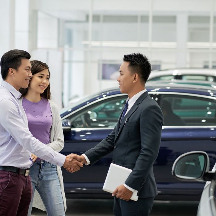 Car salesman shaking hand with client