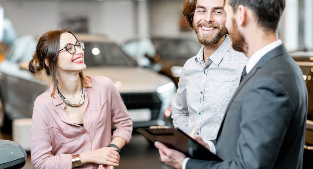 Car salesman talking with couple