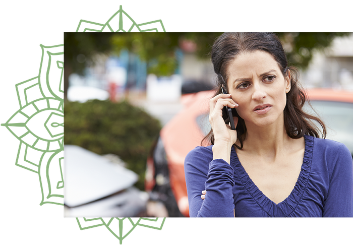 Image of an unhappy woman on her phone in front of a traffic collision