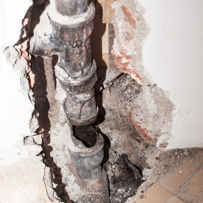 cracked lead pipe in a wall