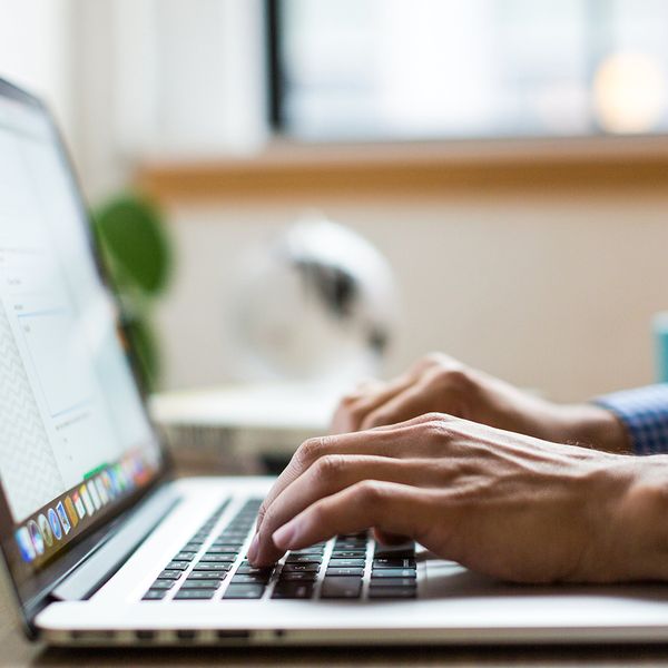 A person working on a laptop connected to a virtual desktop. 