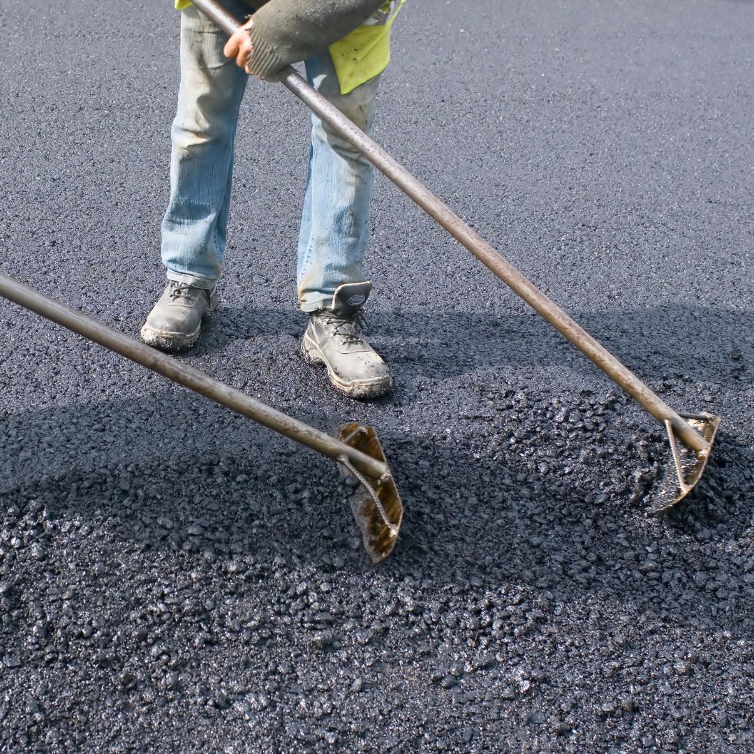 workers smoothing out new asphalt