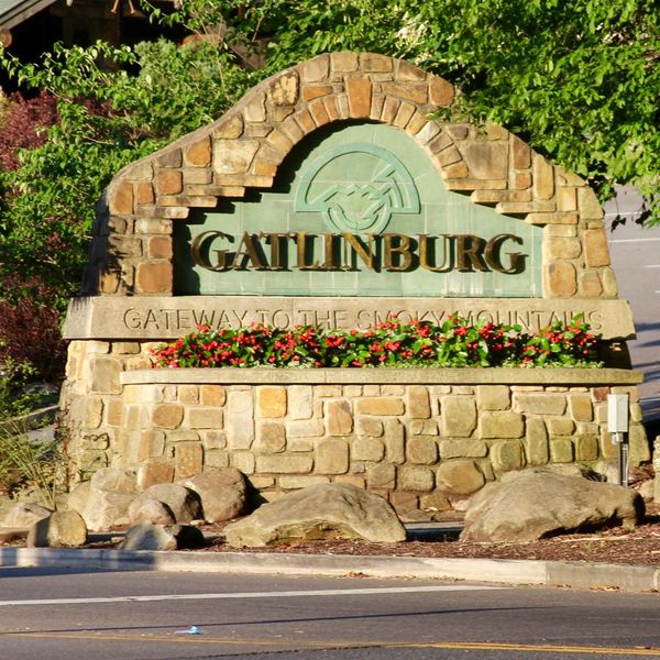 Sign for the city of Gatlinburg, reads "Gatlinburg Gateway to the Smoky Mountains"