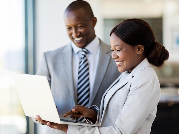 Happy business man and woman smiling while using a laptop