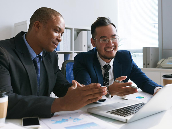 Two business men smiling and looking at a laptop Two business men smiling and looking at a laptop