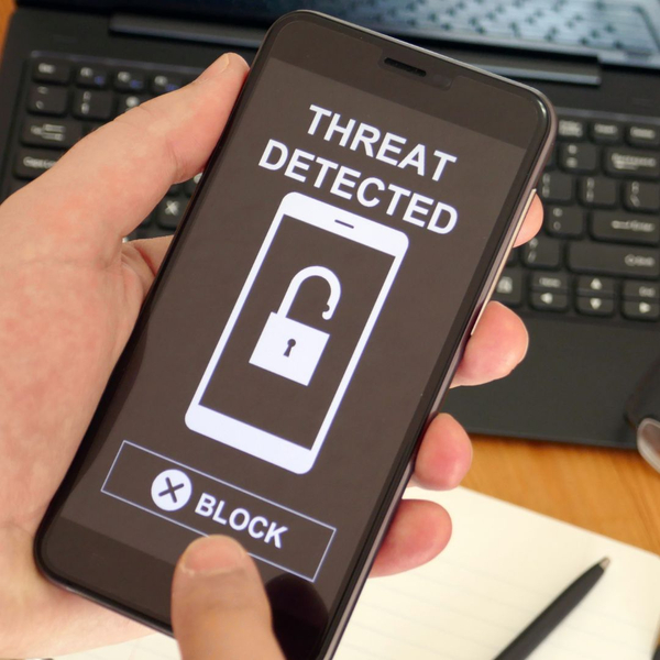 Phone with a screen that says "Threat Detected" and a "Block" button. 