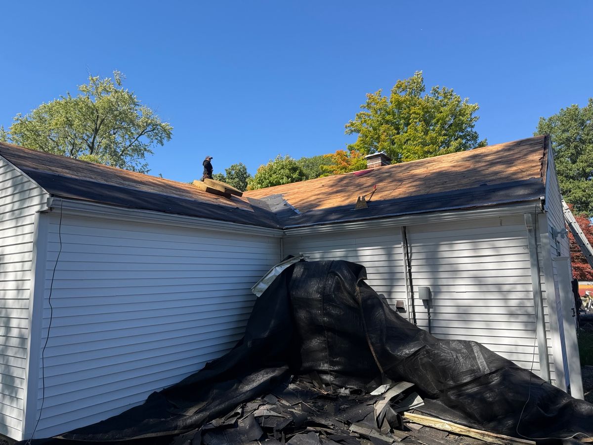 Stripping off old shingle and inspecting roof decking on house in Natick, MA by Natarelli & Son Roofing and Gutters