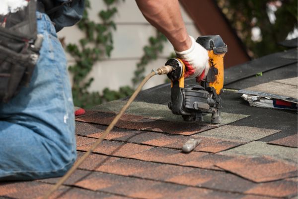 Roofer installing shingles