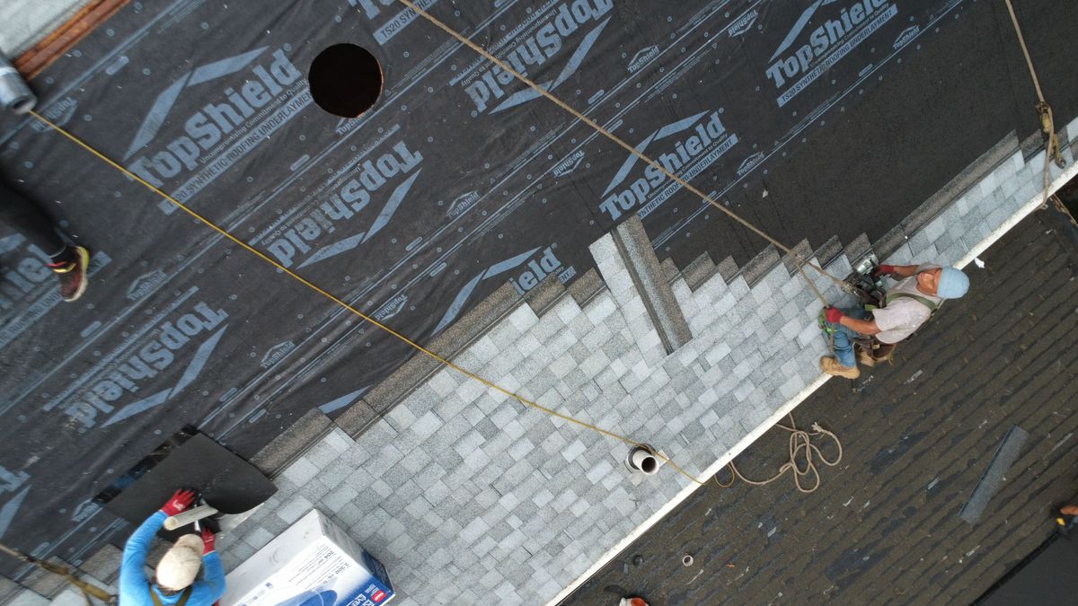 Crew installing architectural shingle on roof in Wellesley MA