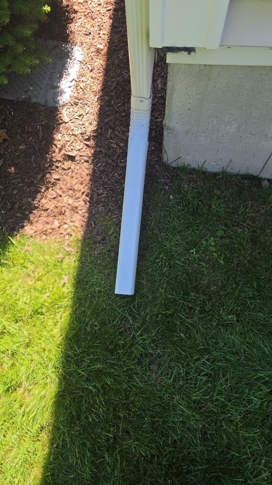 Installing a downpipe extension to lead water away from a foundation.