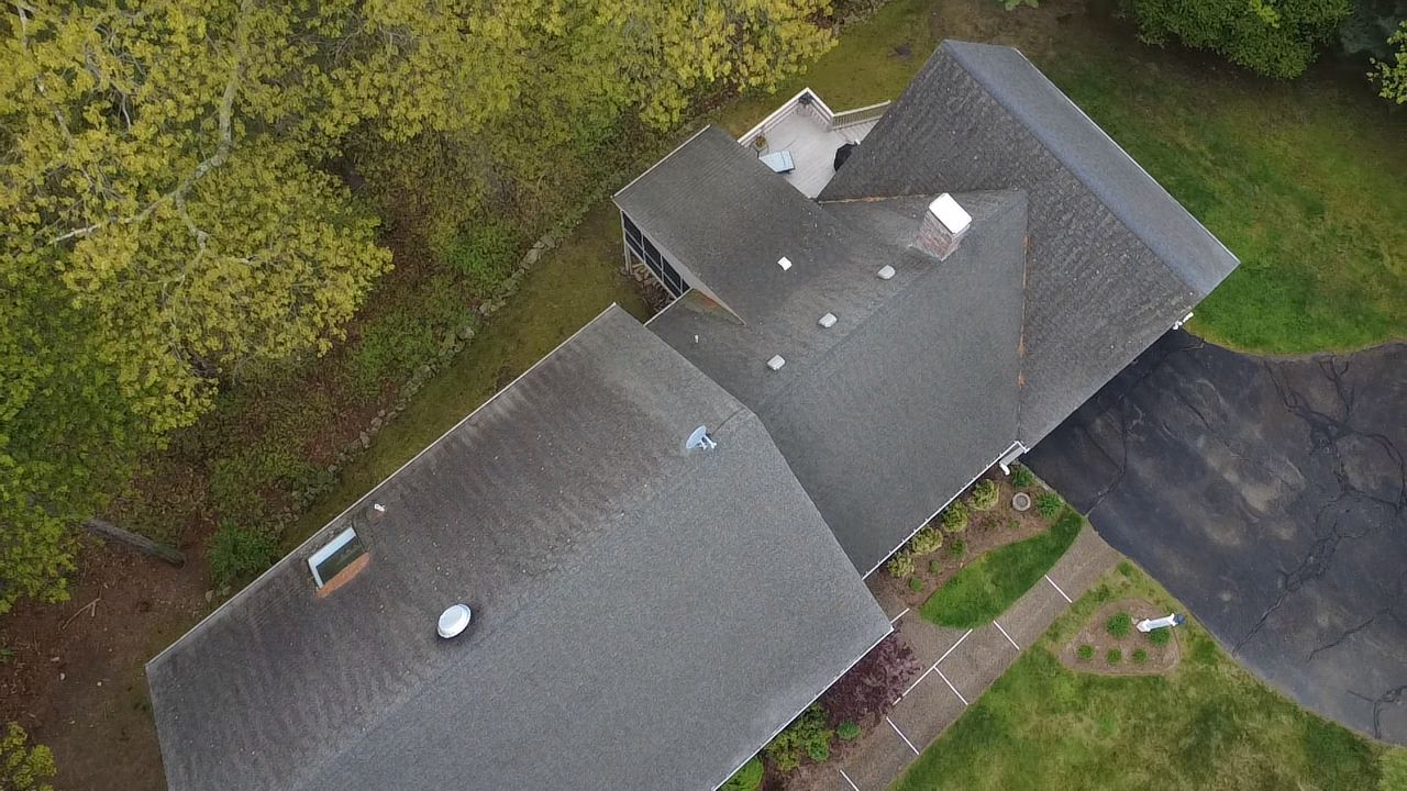 Old roof with worn shingles before roof replacement in Walpole MA