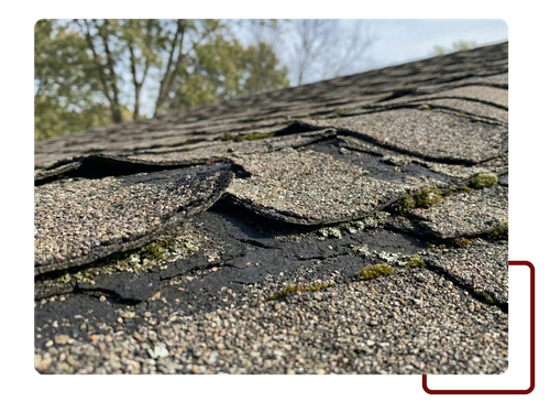worn asphalt roof shingles showing curling edges and surface wear