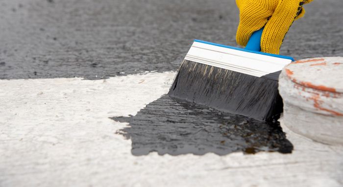 concrete coat being applied with brush