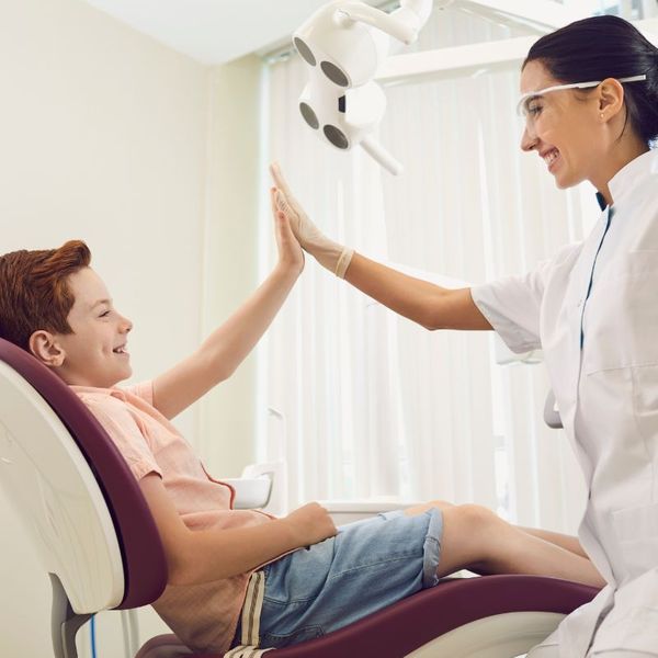 Dentist and child giving a high-five in clinic