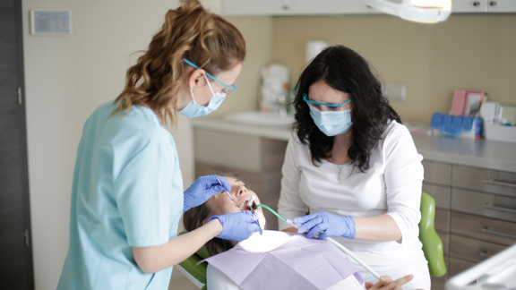 hygienists working of cleaning patients teeth in chair hygienists working of cleaning patients teeth in chair