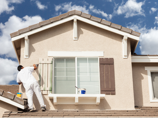  Image of a house painter painting a home exterior. 