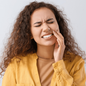 woman holds mouth with tooth pain