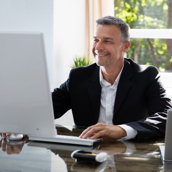 man smiling at computer screen