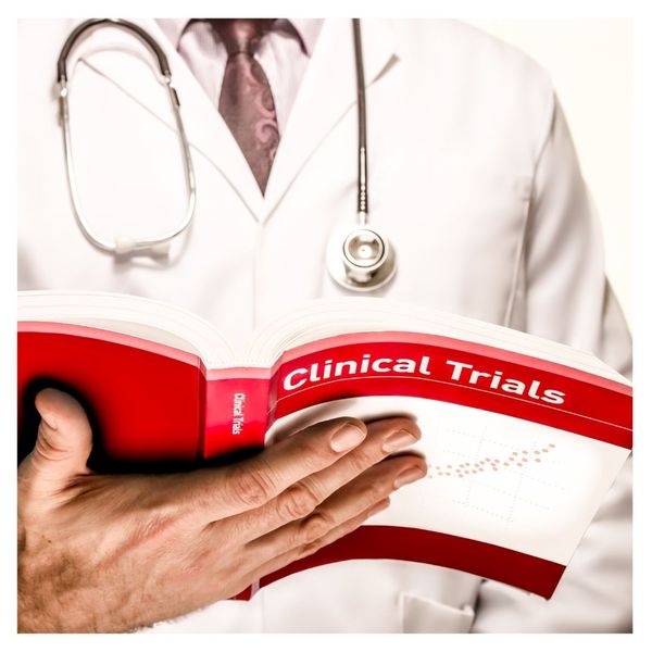 Doctor reading a book titled Clinical Trials