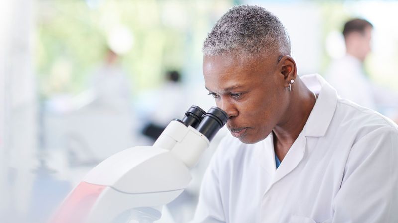A biologist looking through a magnifying class