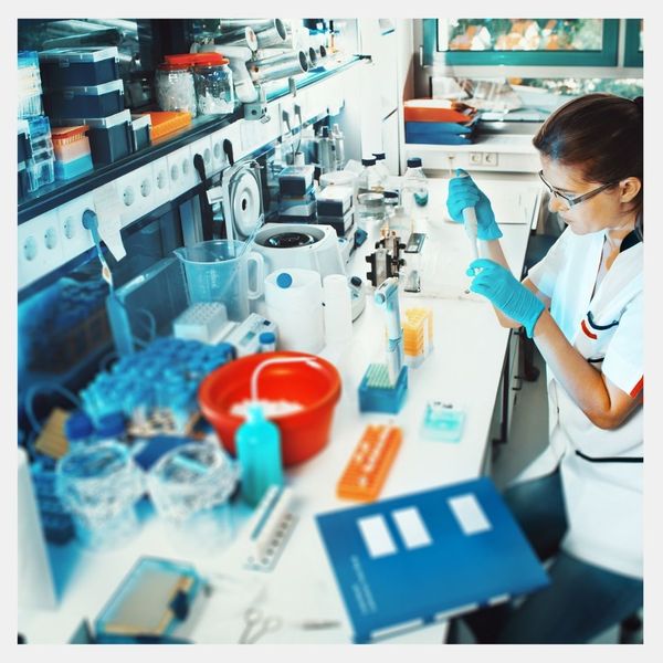 Pharma worker placing something into a tube