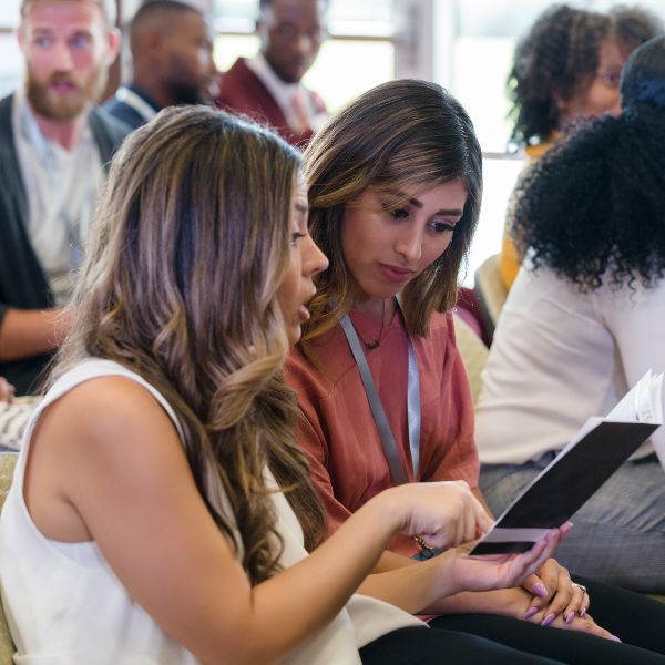 two women looking at conference program