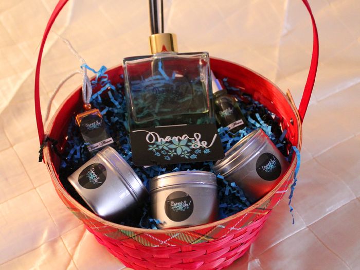  A red gift basket with three hawaiian-inspired candles and scented oils from Ohanale.